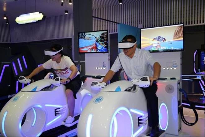 兩客人正在vr體驗館體驗刺激的vr摩托 兩客人正在vr體驗館體驗刺激的vr摩托